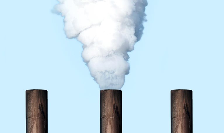 Five smoke stakes line up against a backdrop of a blue sky. A thick cloud of white smoke pours out from one of the stakes.