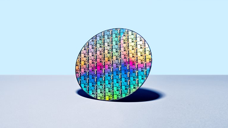 Colorful Iridescent Silicon Computer Wafer on Blue Colored Background.