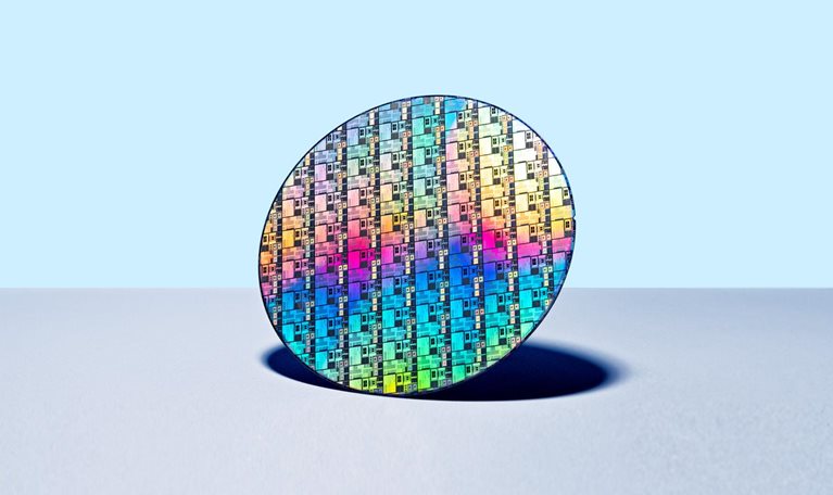 Colorful Iridescent Silicon Computer Wafer on Blue Colored Background.