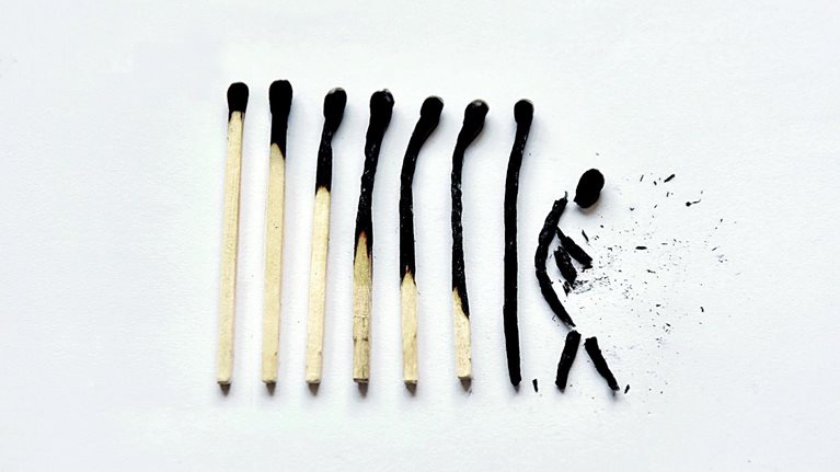 A row of 8 matches that go from lightly to completely burnt. The last match is broken into a shape that resembles a human figure. 