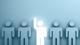 One glowing light man raising his hand among other people