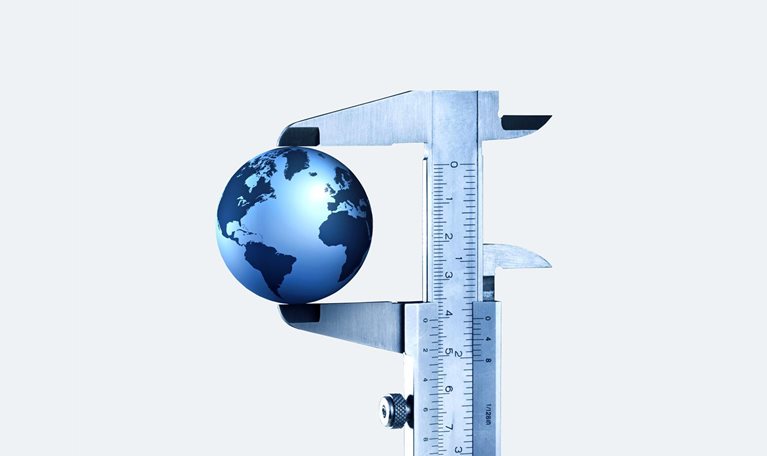 A globe in a vernier caliper set against a light gray background.