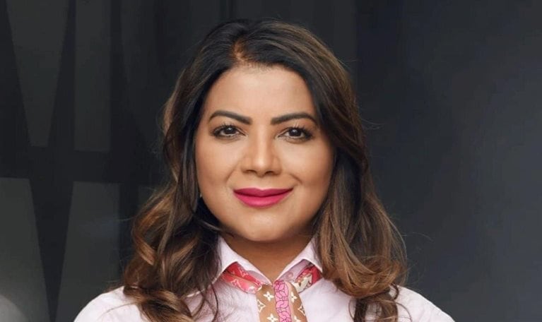 Jeniffer Ramnath with a light smile and wearing a pink top and patterned scarf.