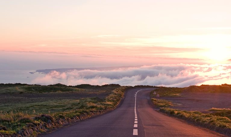 A long country road trailing off into the clouds