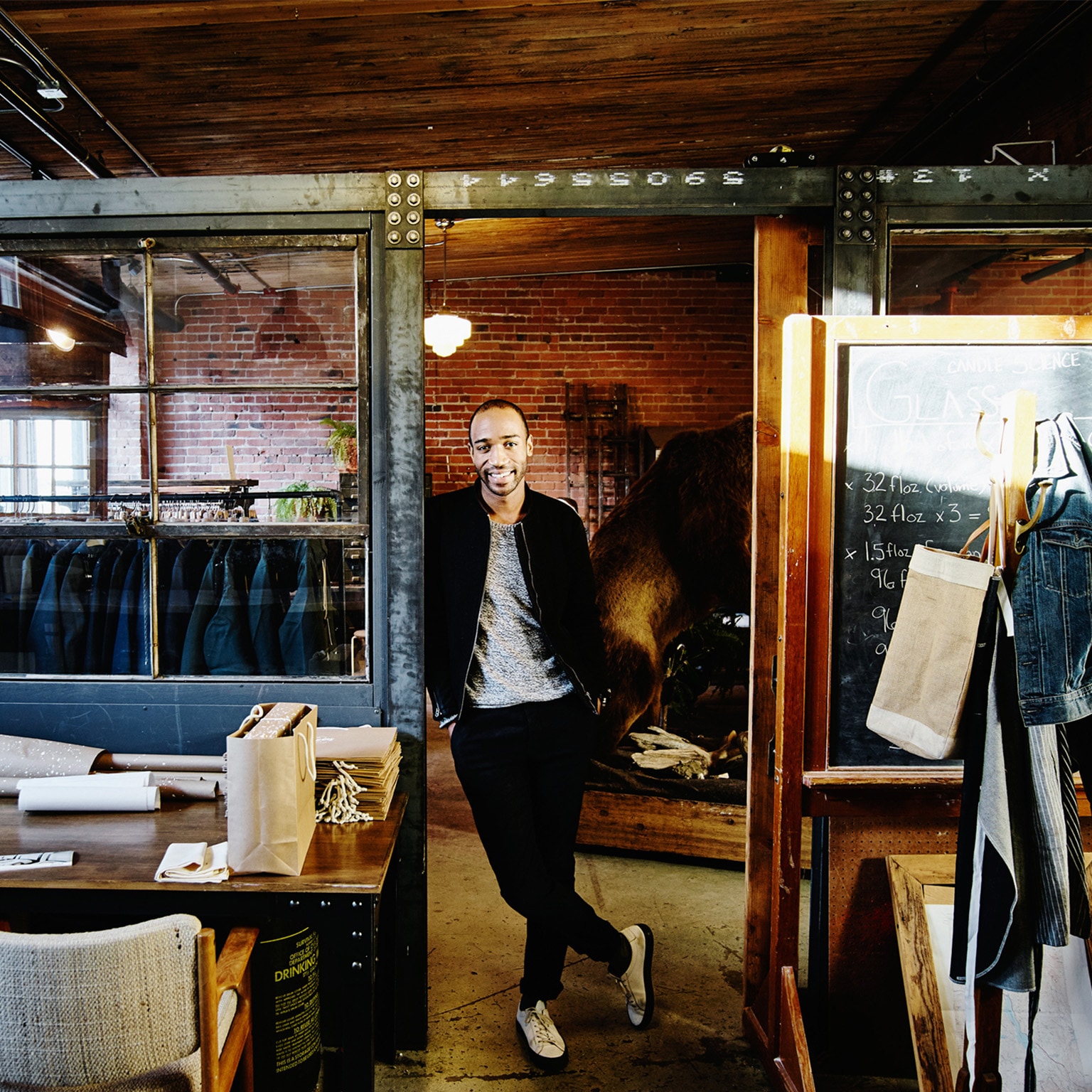 Young business professional leaning in a doorway.