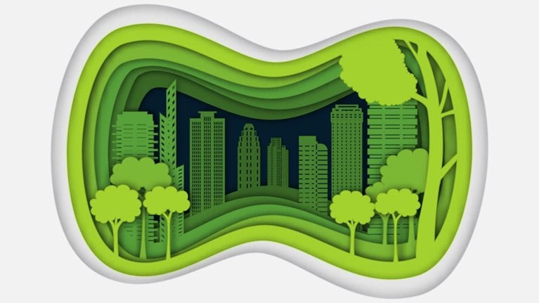 Paper cut image of a city with trees and tall buildings inside it.