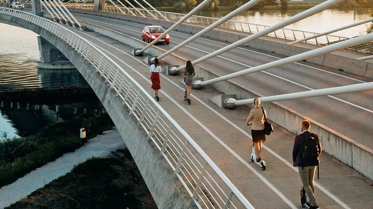 Four people on electric push scooters