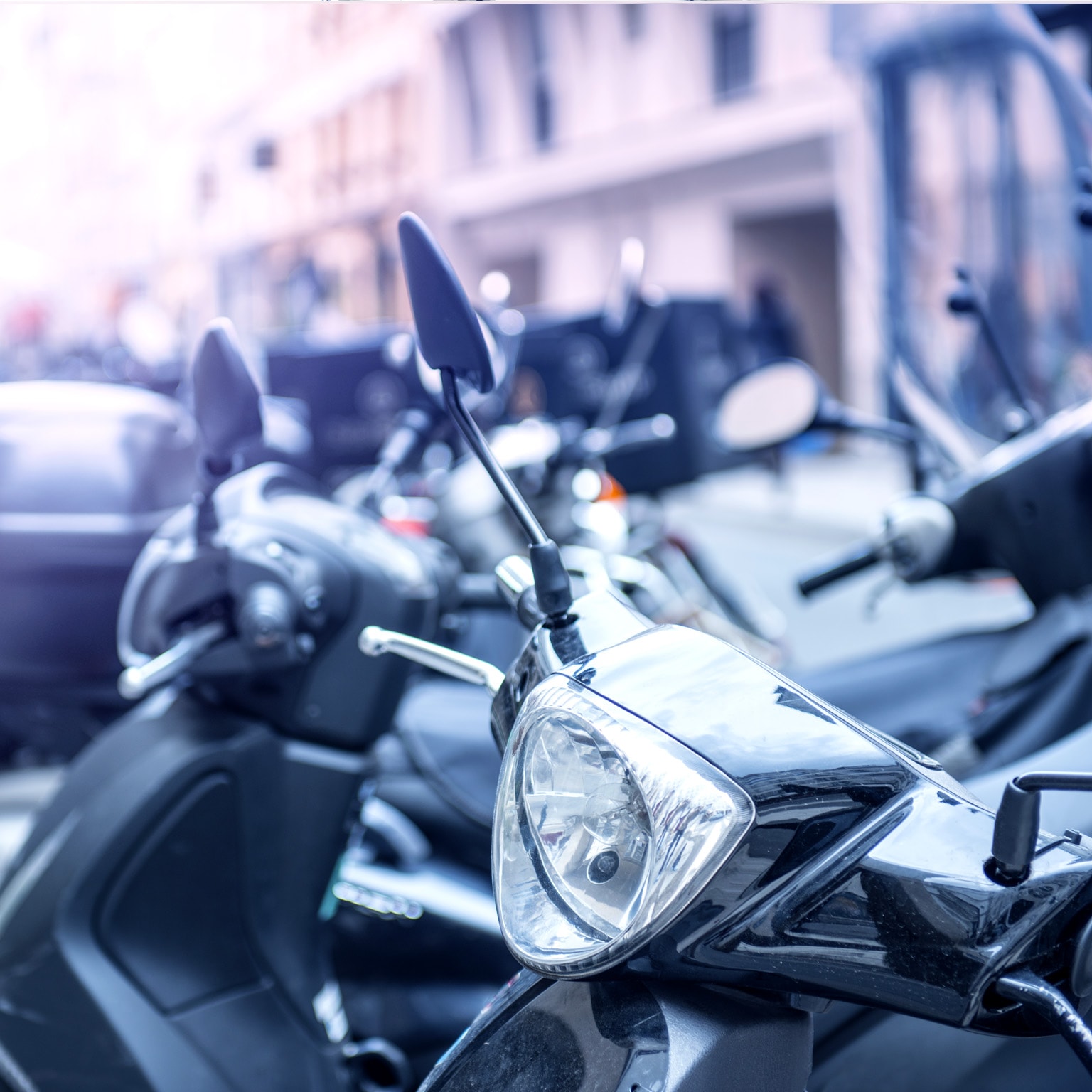 Multiple mopeds on the street in a European city.