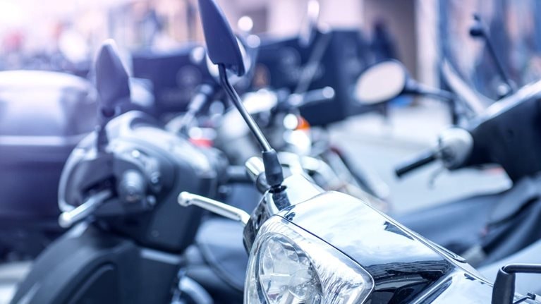 Multiple mopeds on the street in a European city.