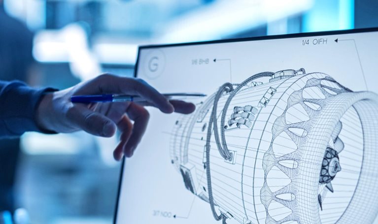 A detailed view of a computer screen displaying a line-work rendering of a prototype jet engine. A specialist's hand gestures towards a specific feature on the prototype.