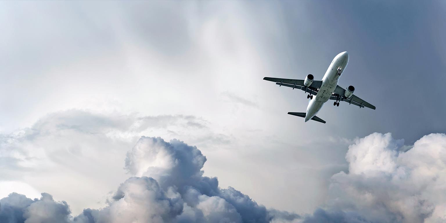 Commercial airliner flying through cloudy sky