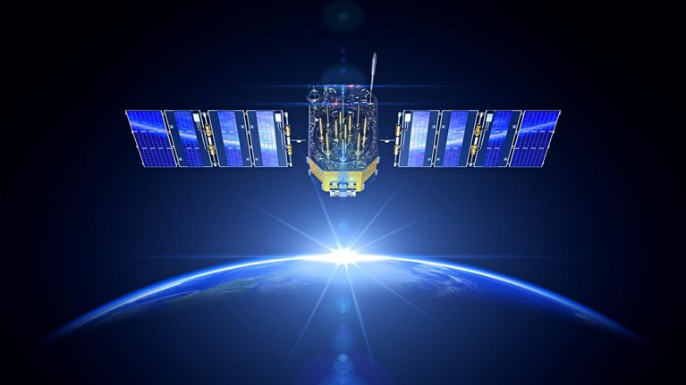 Image of a satellite equipped with two large solar arrays in orbit around the Earth with a view of the planet's blue and white surface with the sun rise glowing on the horizon.