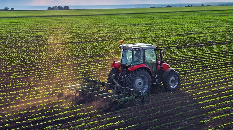 Tractor cultivating field at spring