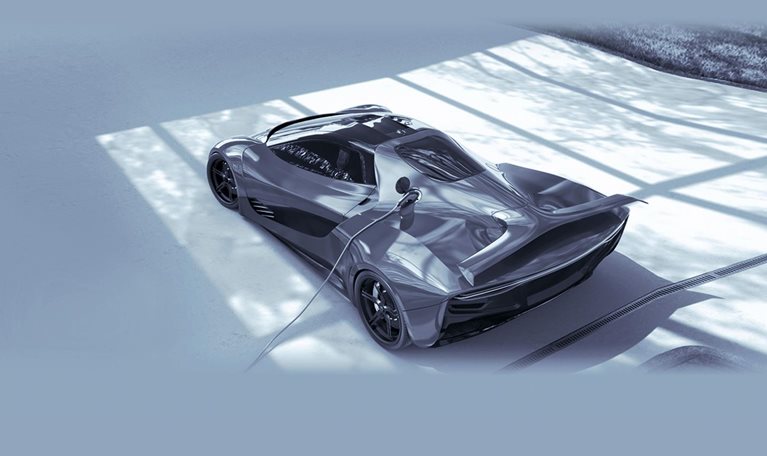 Electric Sports Car Plugged Into Electric Charger On Driveway - stock photo