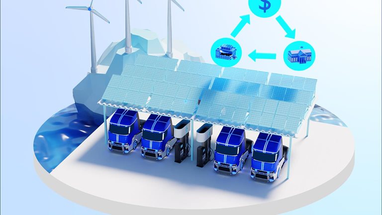 Electric trucks charging underneath solar array with wind turbines spinning in the background.