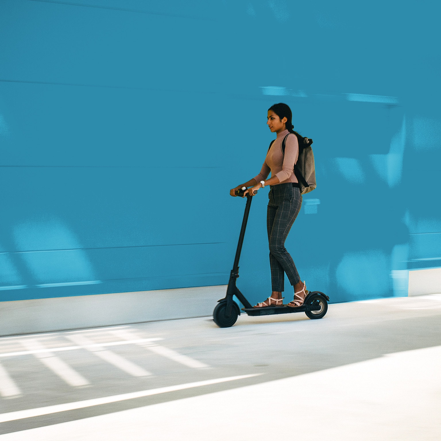 Young businesswoman riding an electric scooter