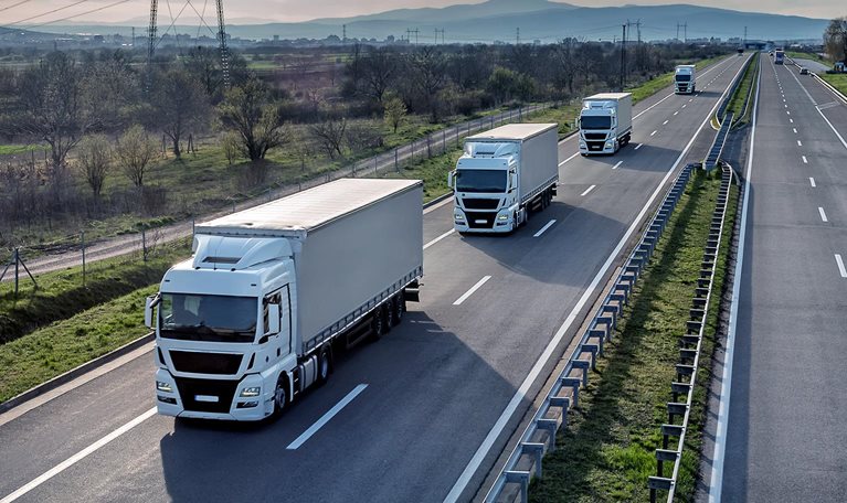 Convoy of trucks driving on a highway