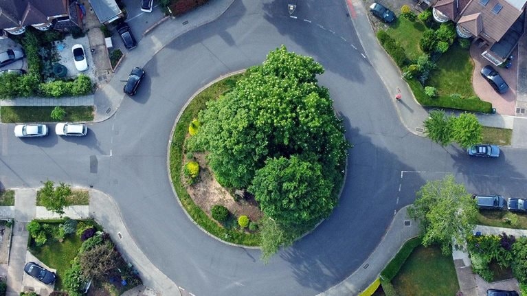 Overhead aerial view of a roundabout and residential housing