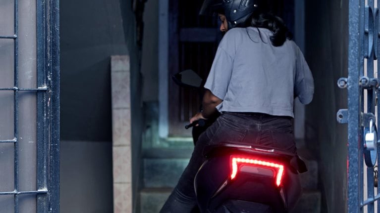 Young Woman parking her electric scooter. - stock photo