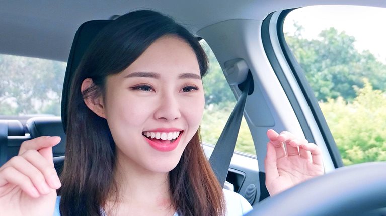 A woman behind the steering wheel of an autonomous self driving car