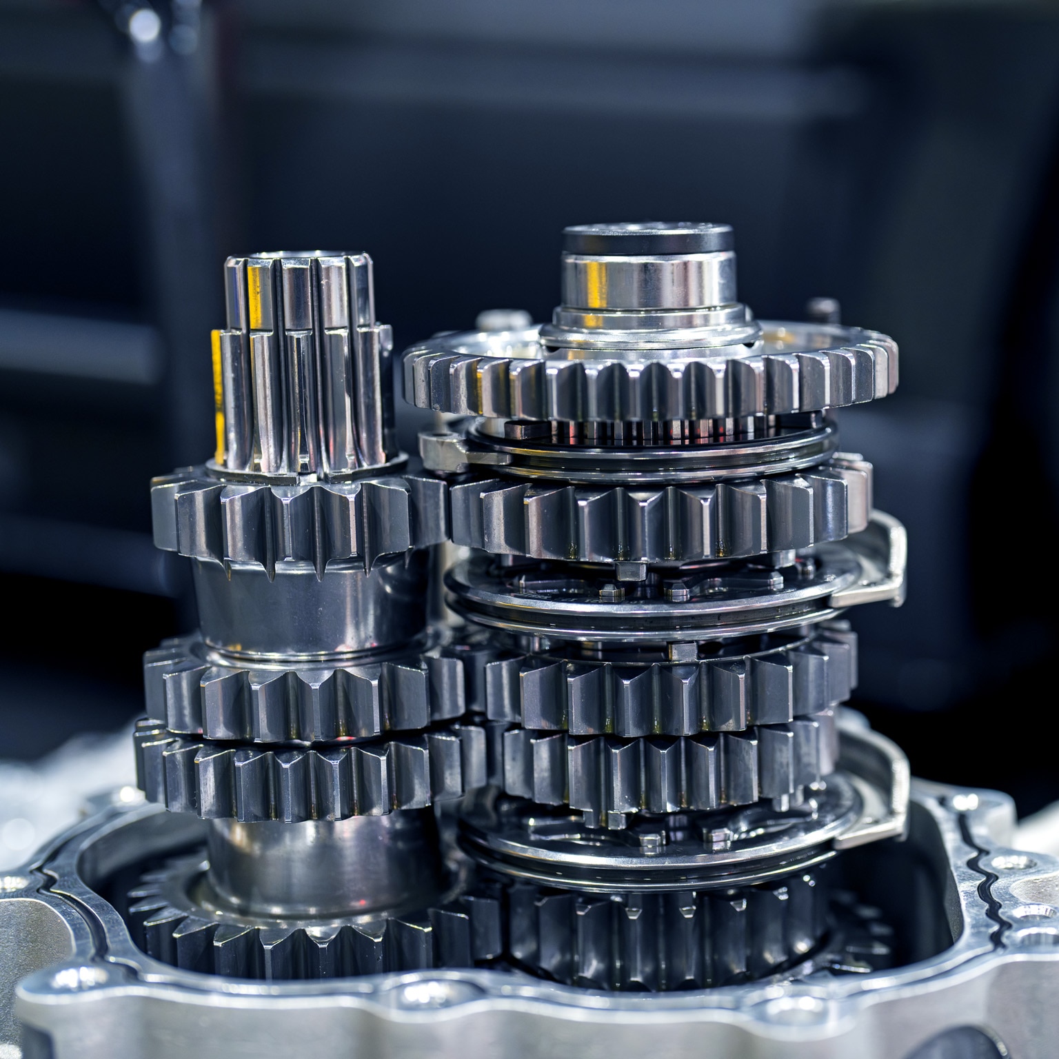 A close-up of a cluster of silver gears arranged in a complex mechanical assembly.