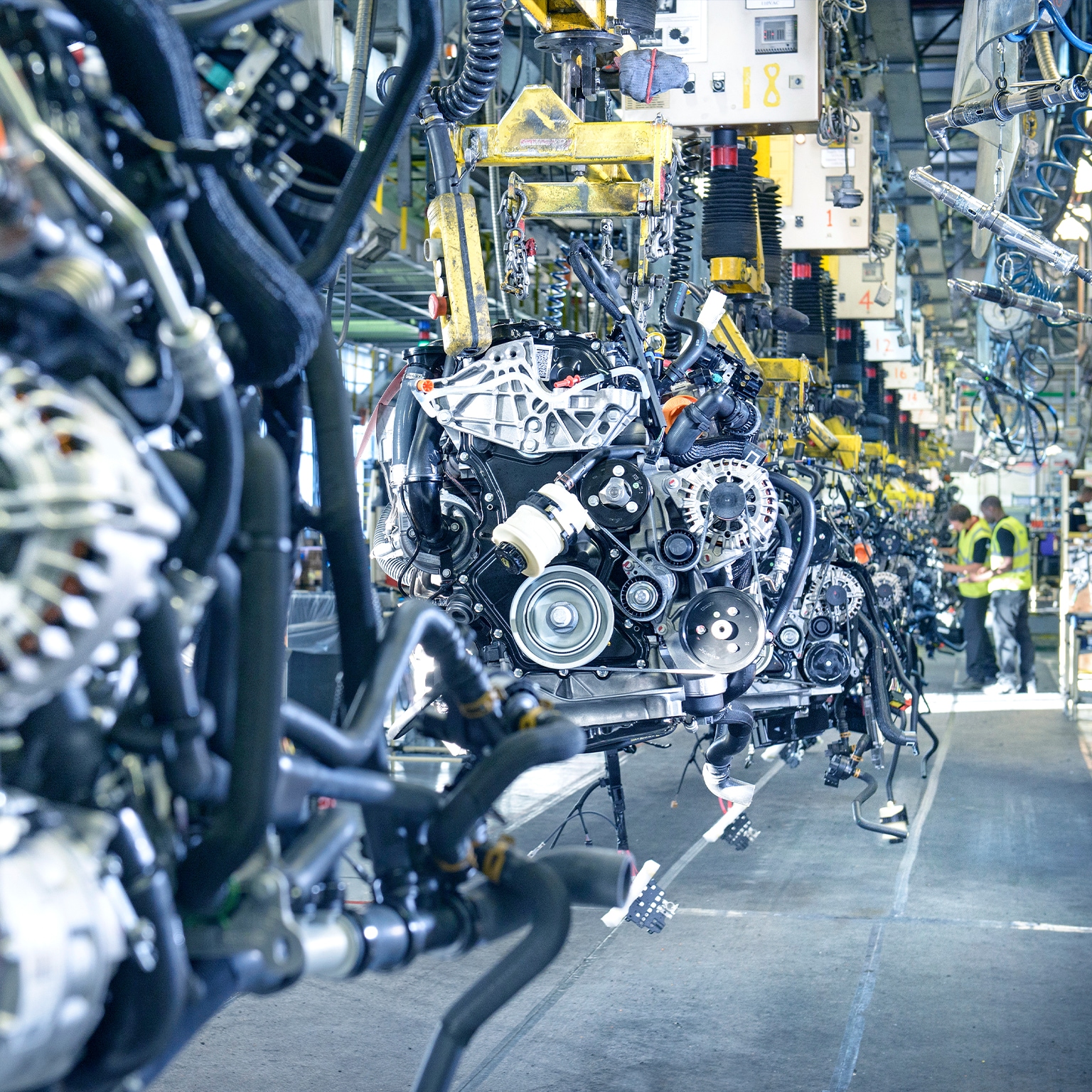 Workers on engine production line in car factory 