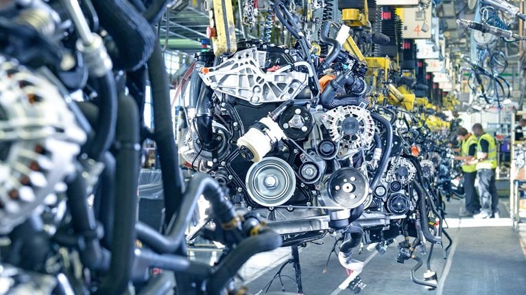 Workers on engine production line in car factory