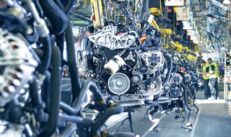 Workers on engine production line in car factory
