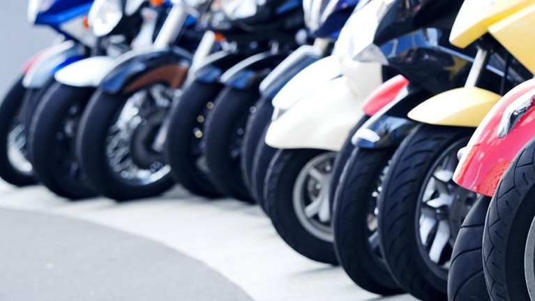 A row of motor scooters standing on the street