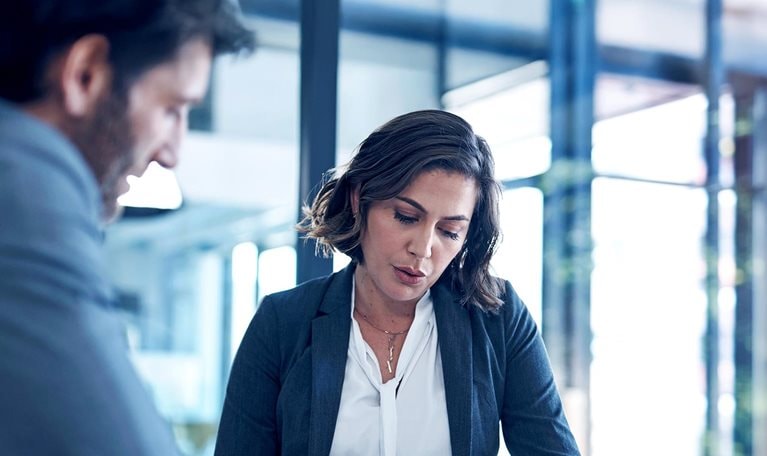 A businessman and businesswoman reviewing paperwork in the office