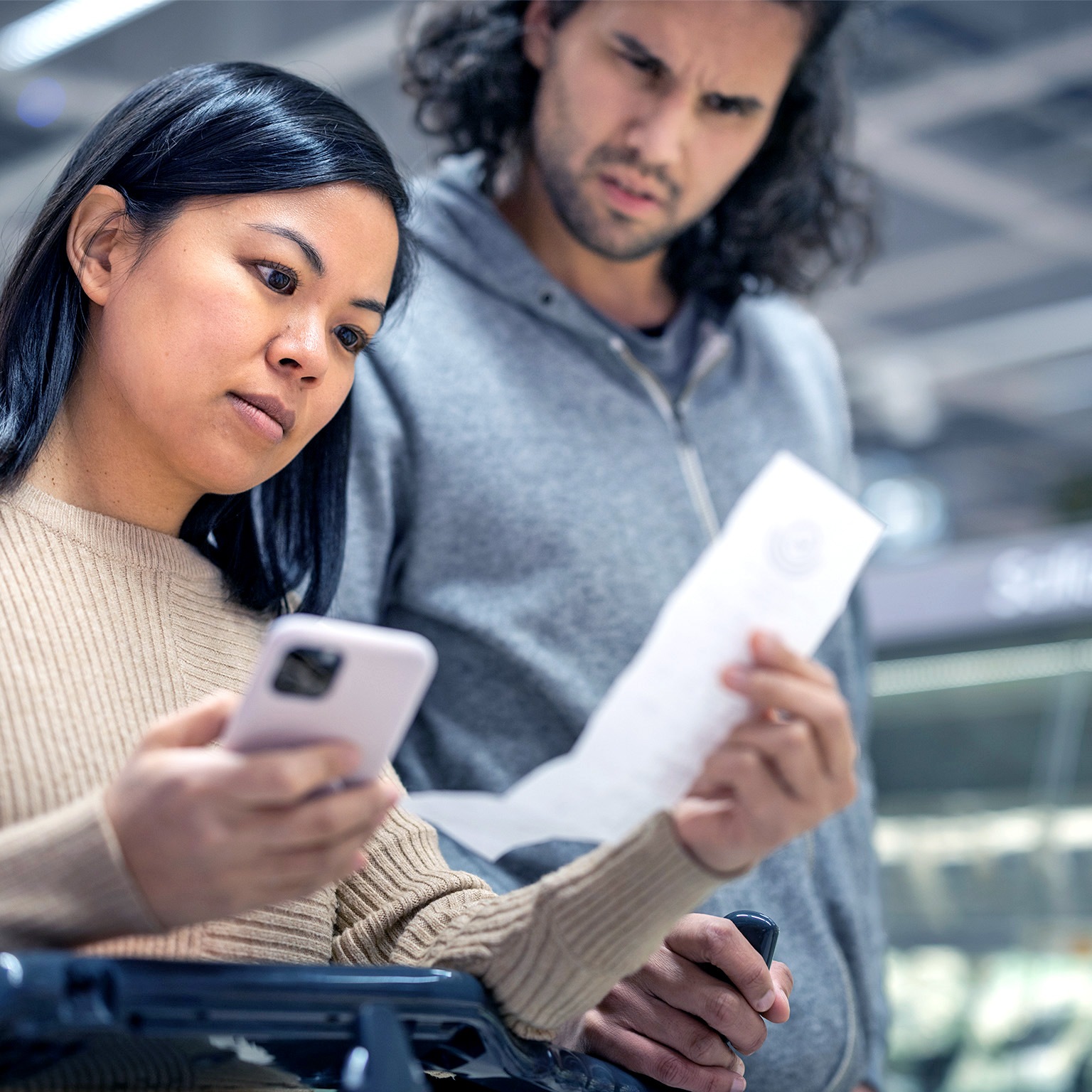 Young couple discussing over receipt at supermarket