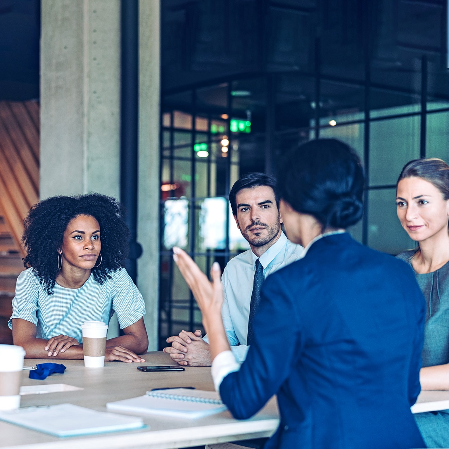 Group of business persons in a meeting inside a modern office.