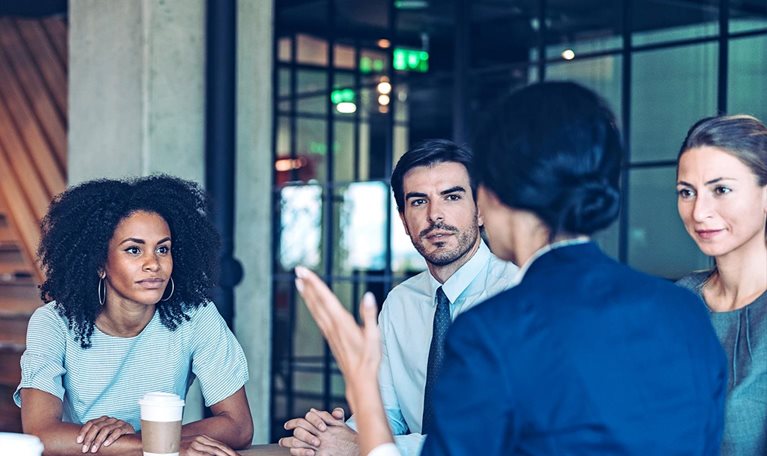 Group of business persons in a meeting inside a modern office.