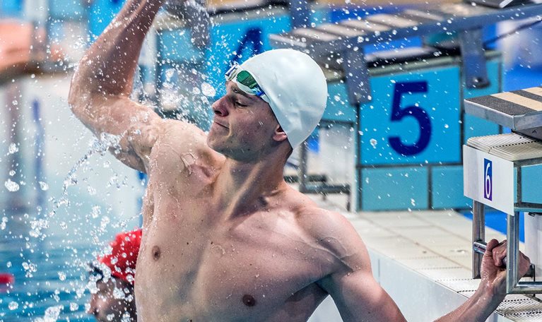 Male swimmer punching the air during swimming competition.