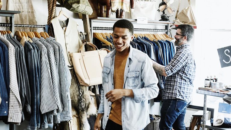 Smiling customers shopping in men's boutique.