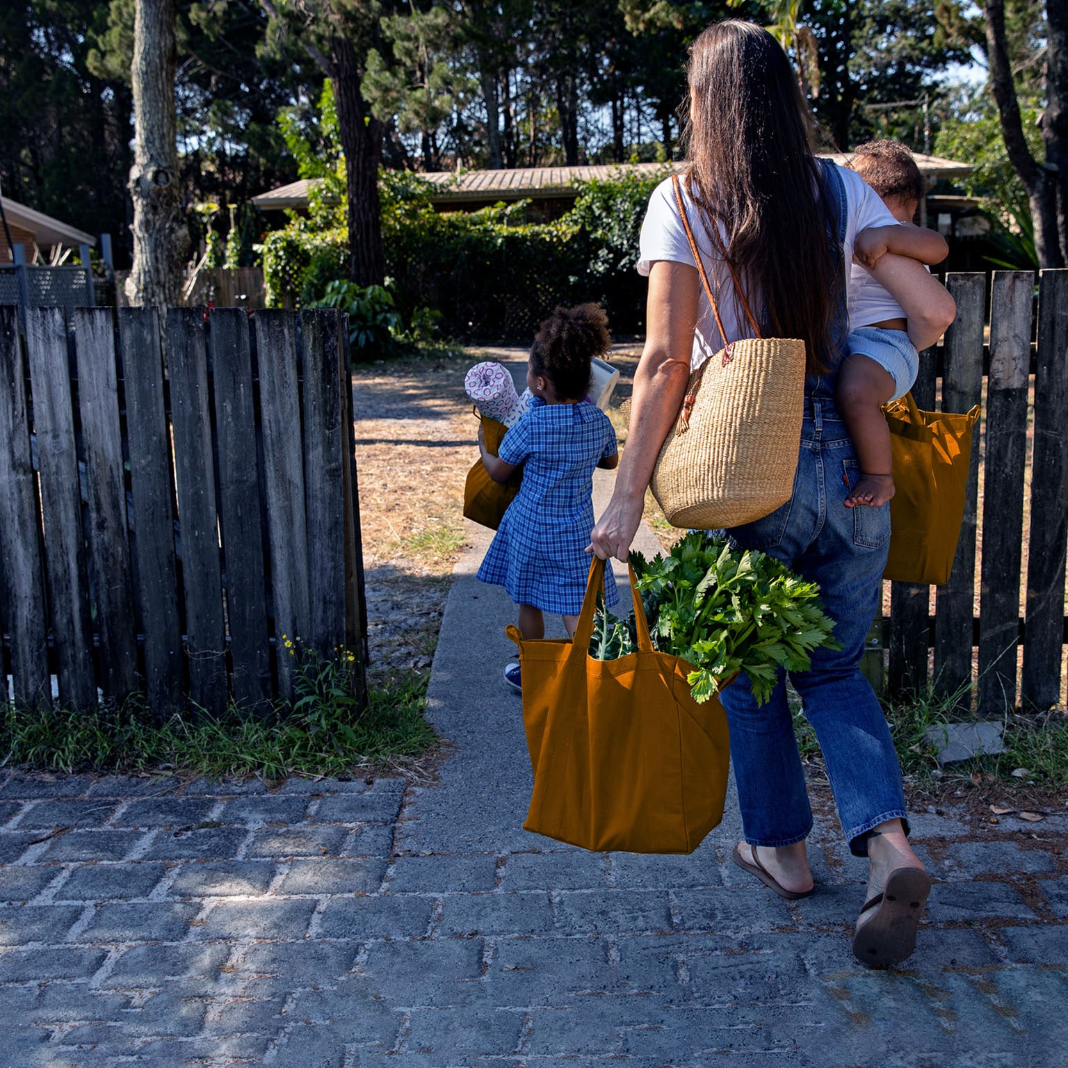 Young Australian family carries the shopping in together and hugs after being at school and work