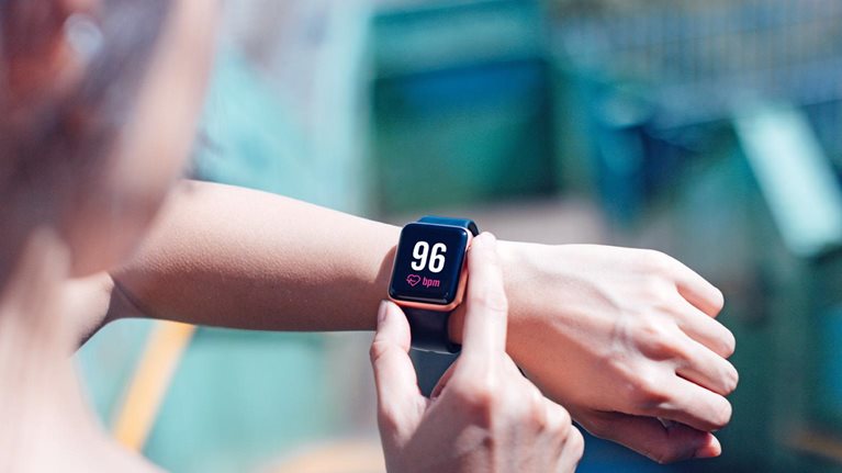 A young woman checking her heart rate on a smart watch.