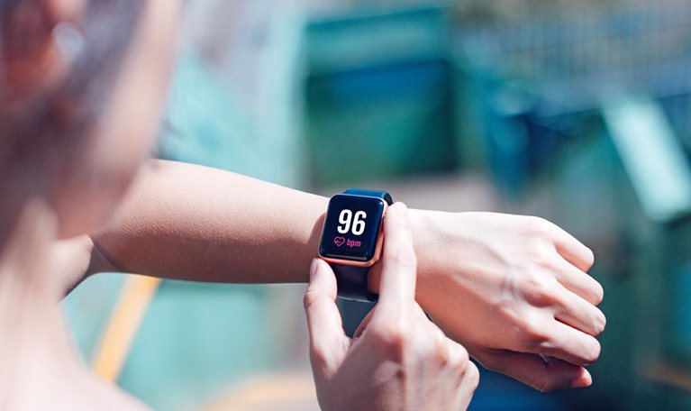 A young woman checking her heart rate on a smart watch.