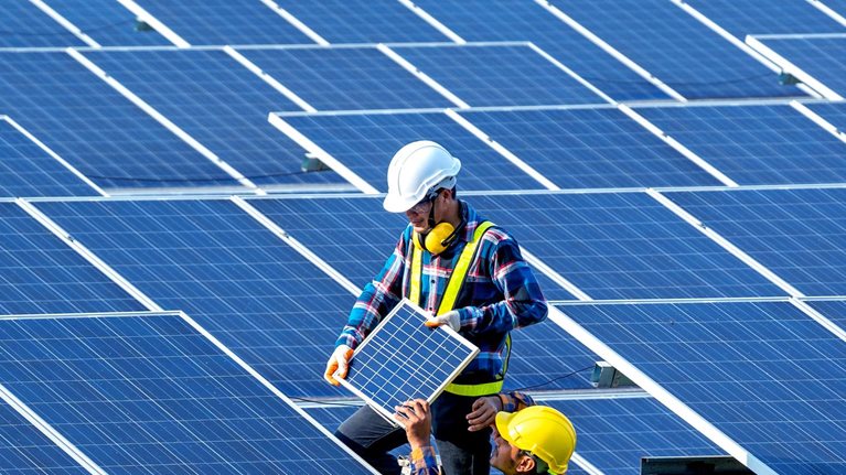 Workers installing solar panels on the roof