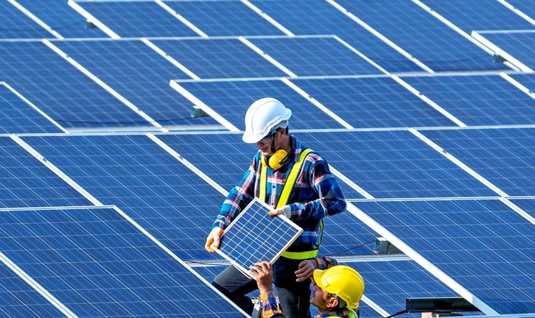 Workers installing solar panels on the roof