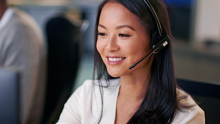 Customer support employee smiling with headset on