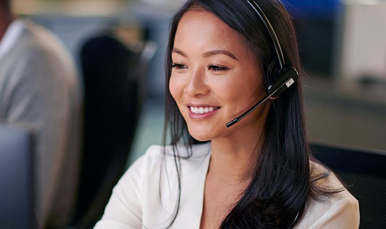 Customer support employee smiling with headset on