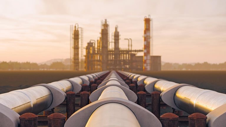 Oil refinery and pipeline in desert during sunset