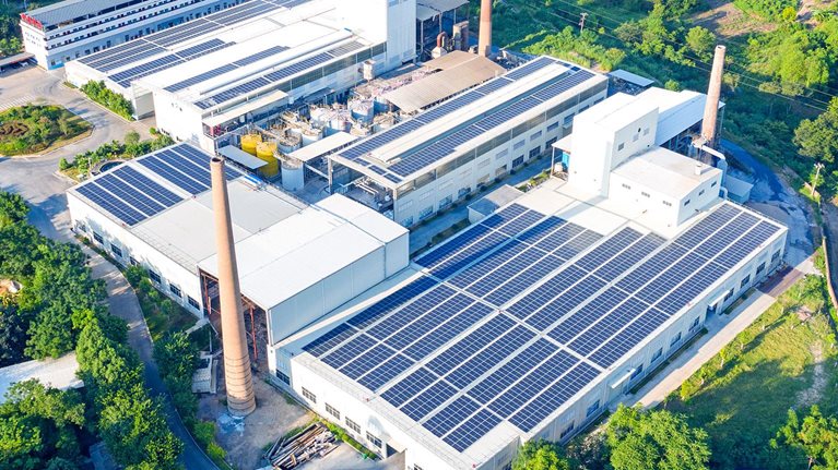 The roof of the factory is covered with solar photovoltaic panels - stock photo
