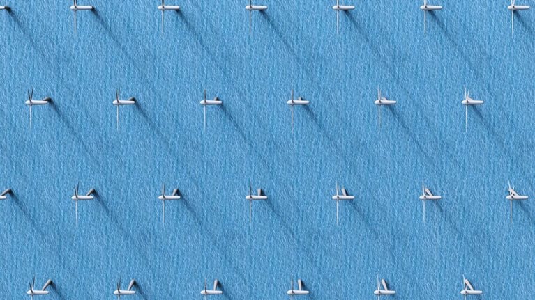 An aerial view of wind turbines in the ocean