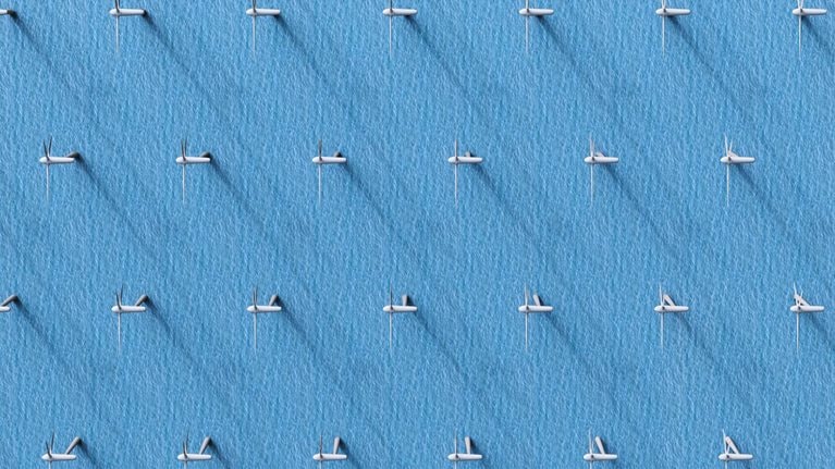 An aerial view of wind turbines in the ocean