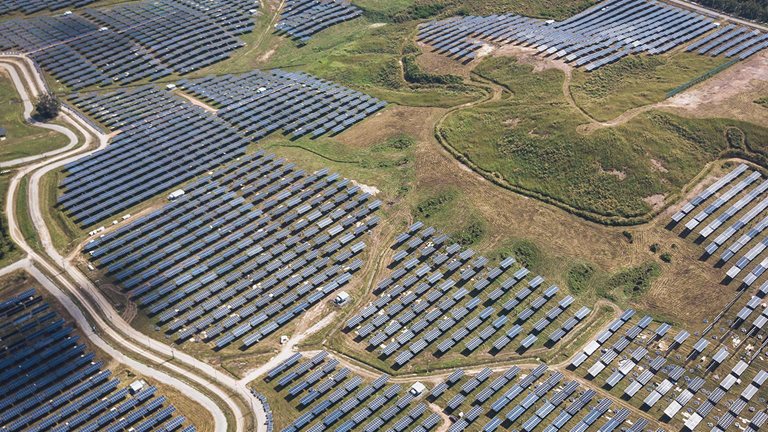 Aerial view of solar panels in solar farm in the rural agriculture field. - stock photo