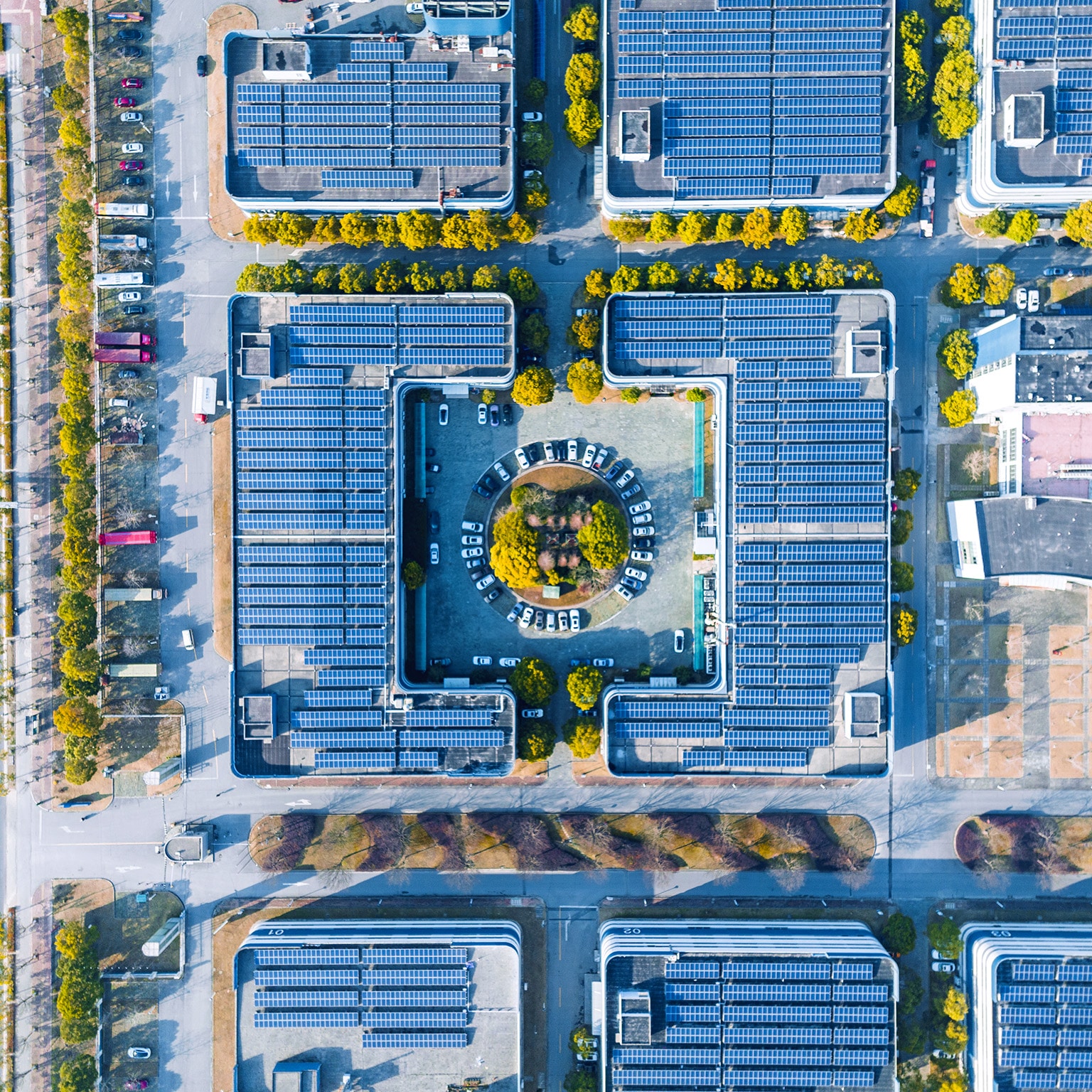 Aerial view of solar panels covering the top of a modern office building.