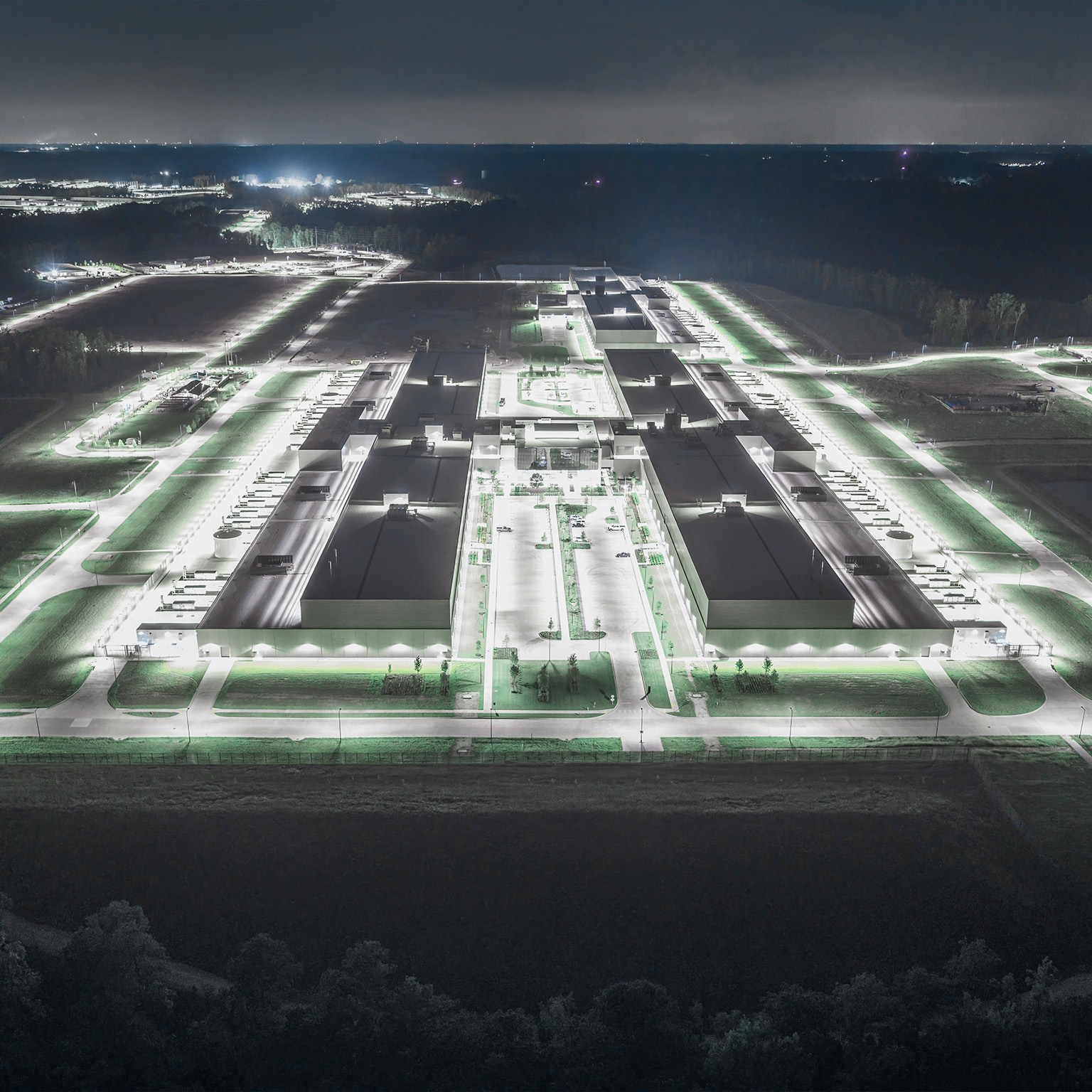 This image shows an aerial view of a Meta data center in Newton County, Georgia, illuminated at night.