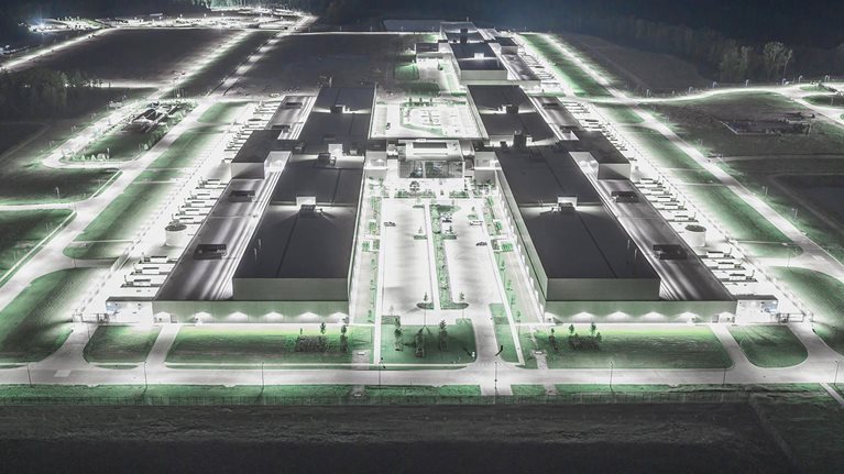 This image shows an aerial view of a Meta data center in Newton County, Georgia, illuminated at night.